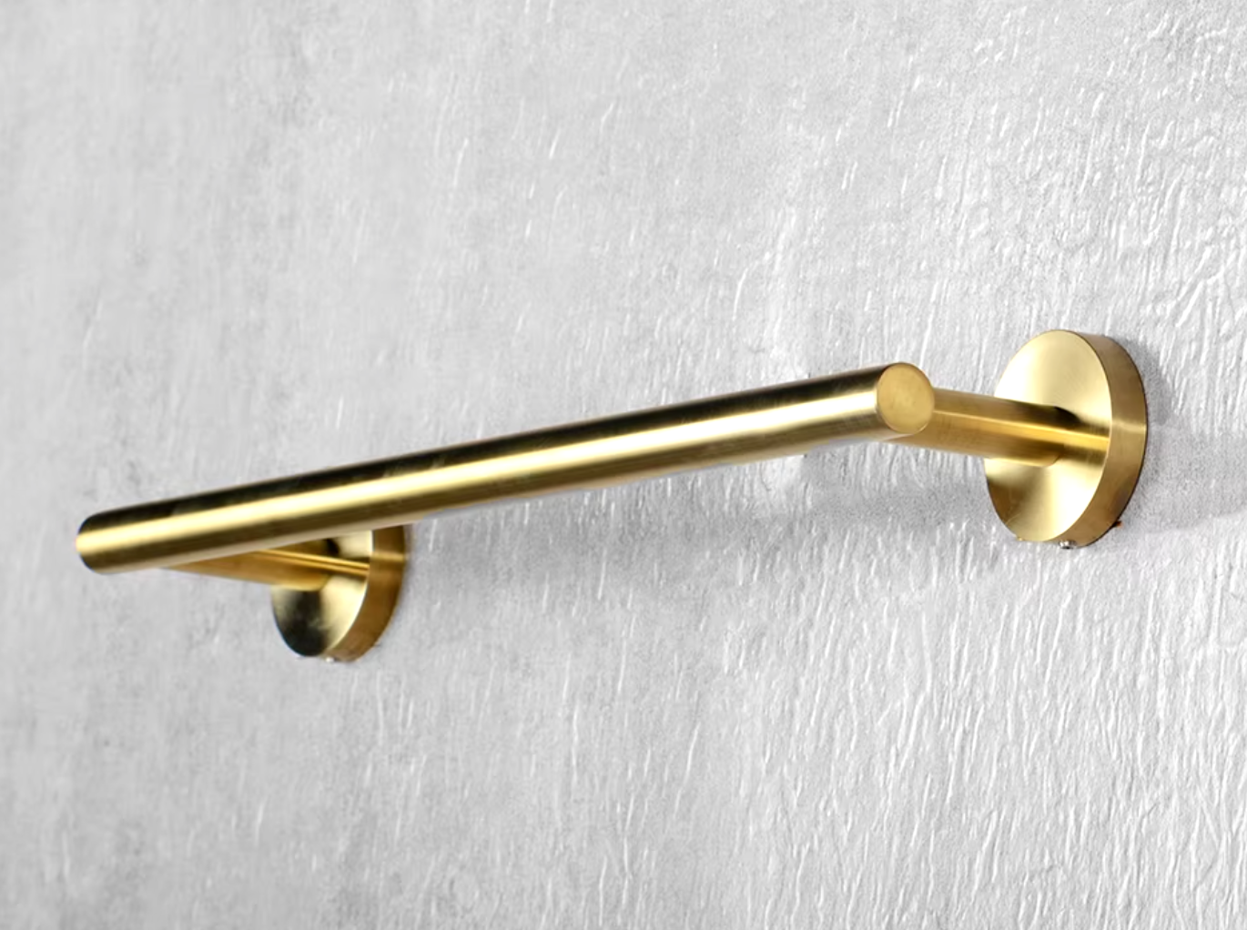 Brushed brass gold towel rail on a wall